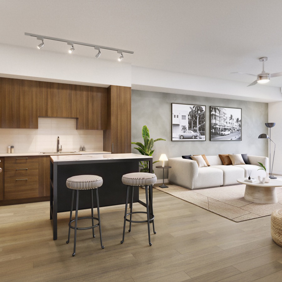 Rendering of an open-concept kitchen and living area at Lakeview at NoMi in North Miami, with dark wood cabinetry, a marble-top island with striped stools, and a living space featuring a white sofa, black-and-white Miami photography, and wood flooring